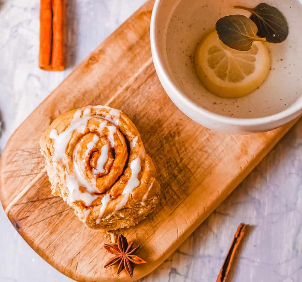 healthy cinnamon rolls, served on a wooden platter with a cup of tea
