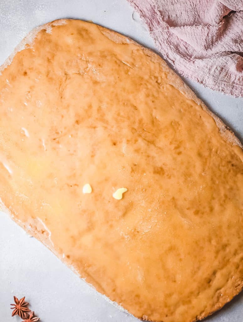cinnamon roll dough rolled out on a cutting board