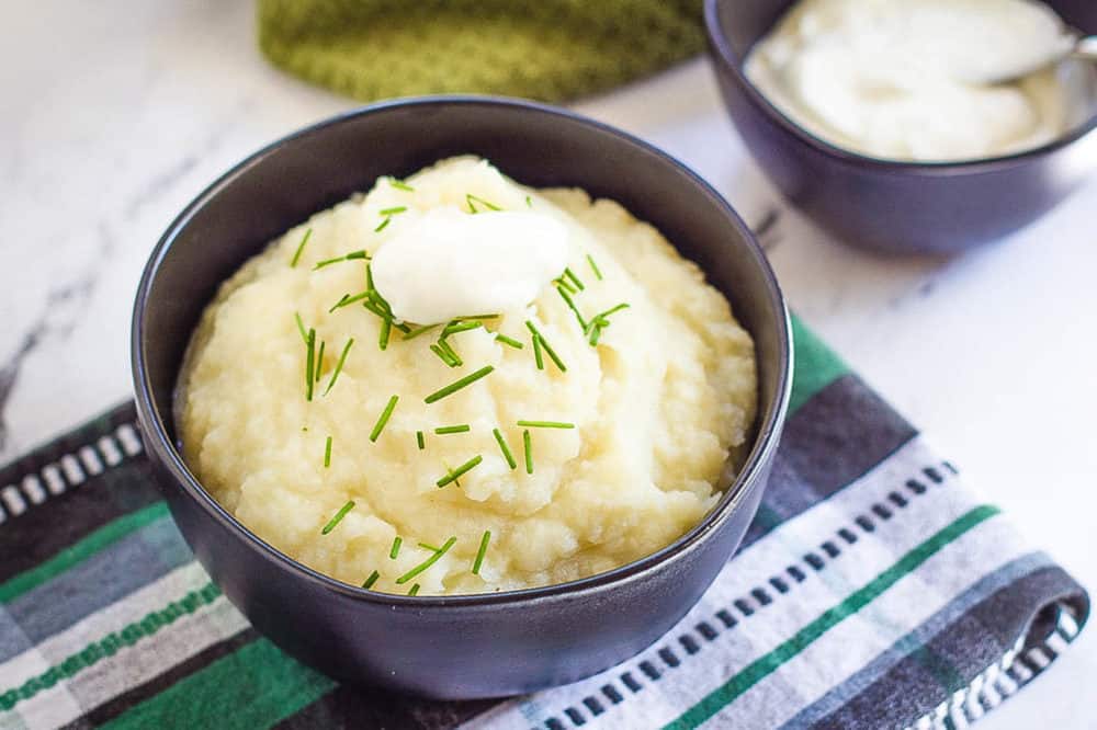 vegan mashed potatoes in a blue bowl against a blue and green cloth