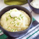 vegan mashed potatoes in a blue bowl against a blue and green cloth