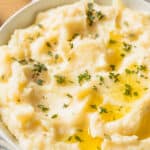 Healthy mashed potatoes in a white bowl against a blue and white cloth.