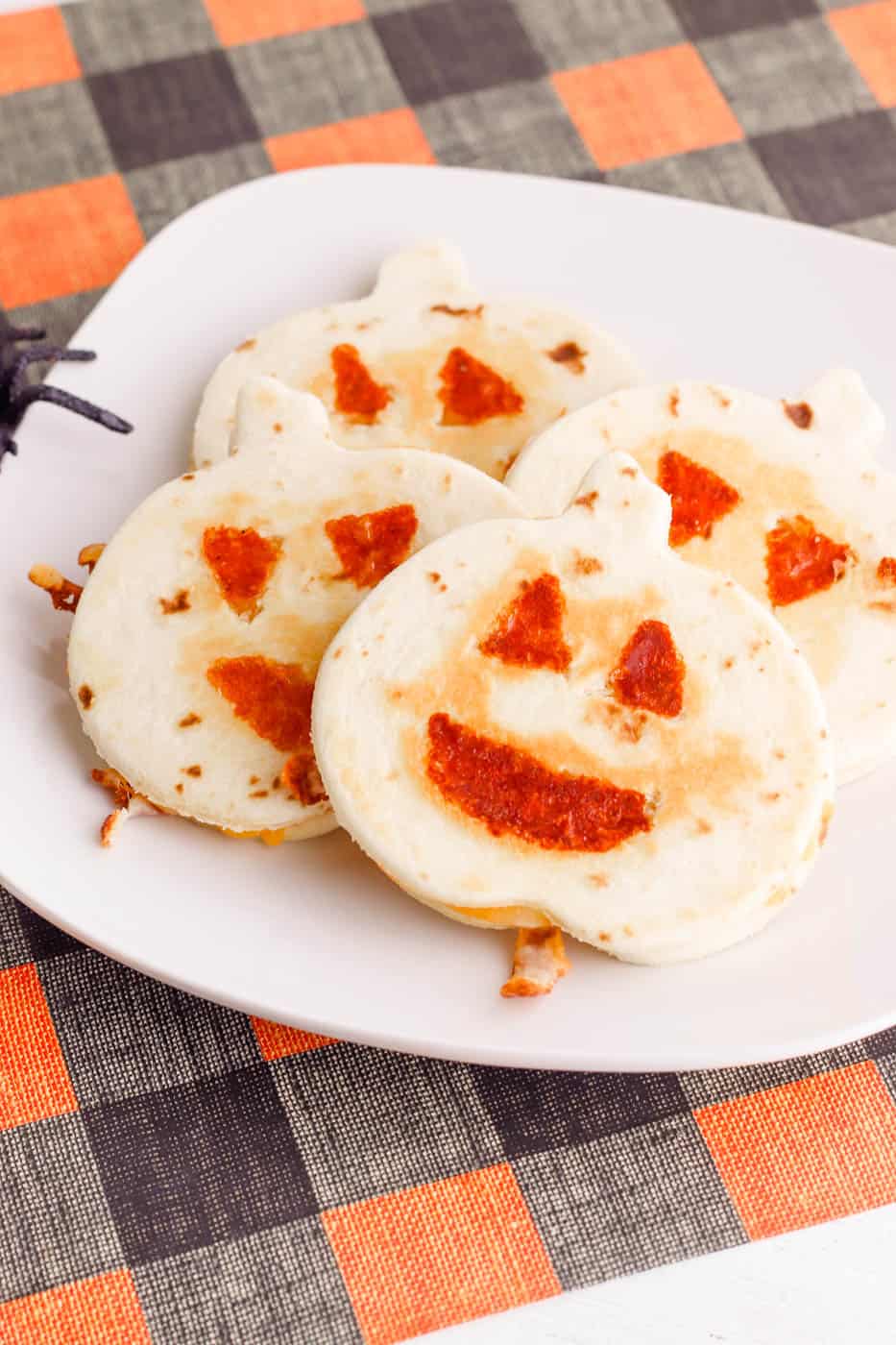 jack-o-lantern pumpkin halloween quesadillas served on a white plate