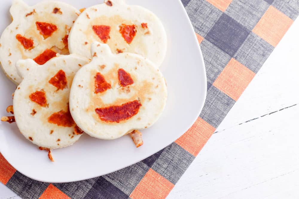 halloween jack-o-lantern pumpkin quesadillas served on a white plate