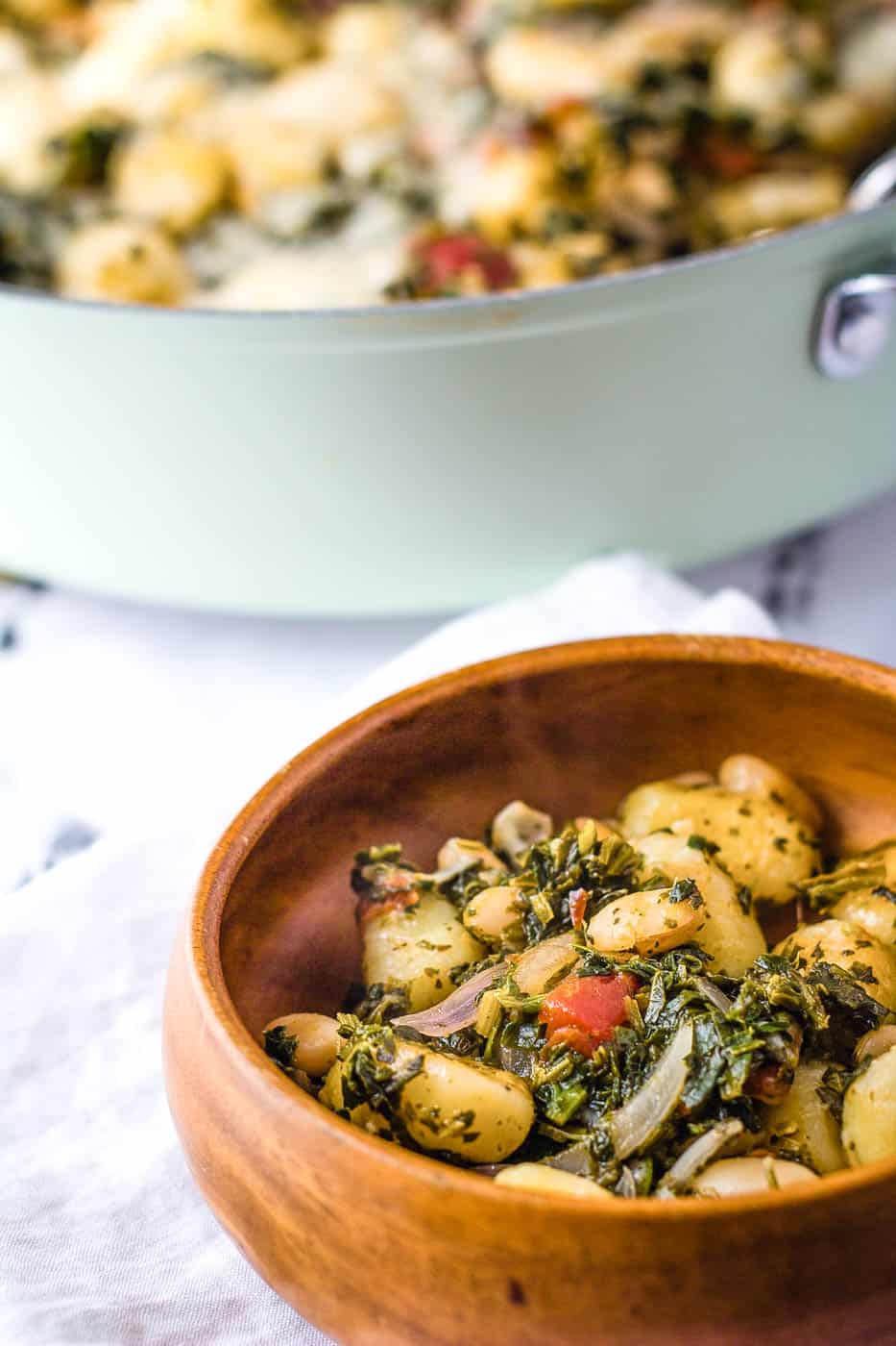 portion of veggie gnocchi in a bowl with the skillet in the background