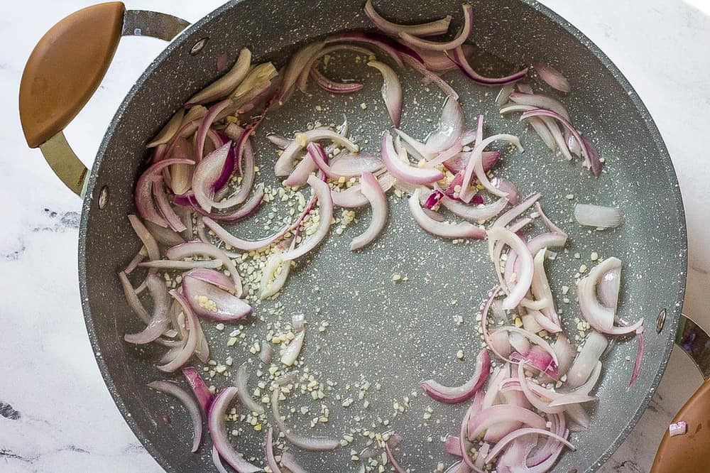 onions and garlic sauteeing in a pan.