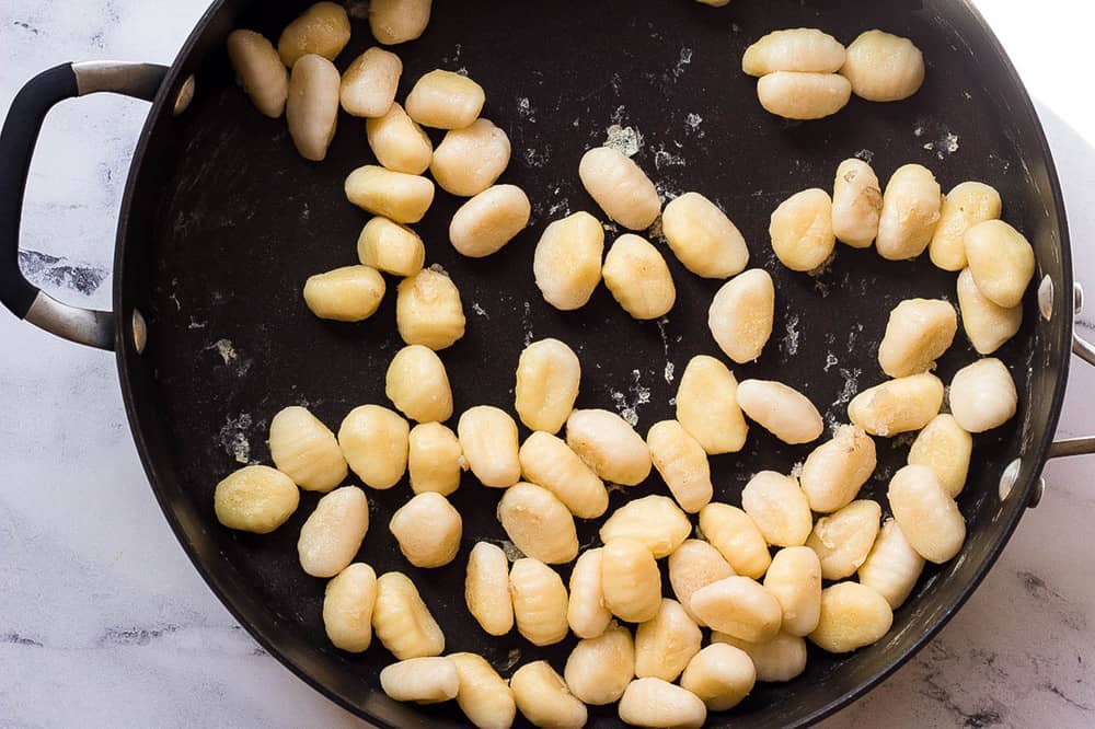gnocchi sauteeing in a pan. 