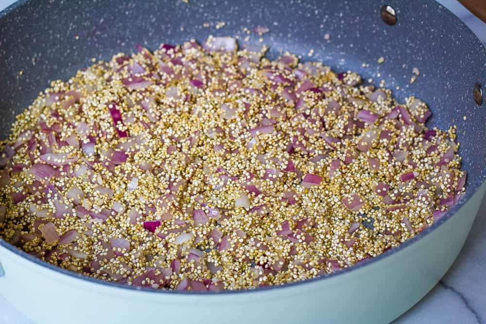 quinoa and onions in a pan