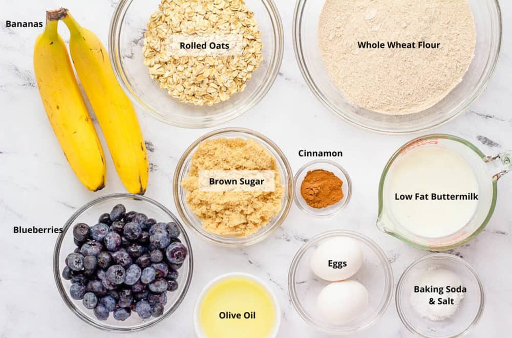 All of the ingredients for blueberry bread on a white background.