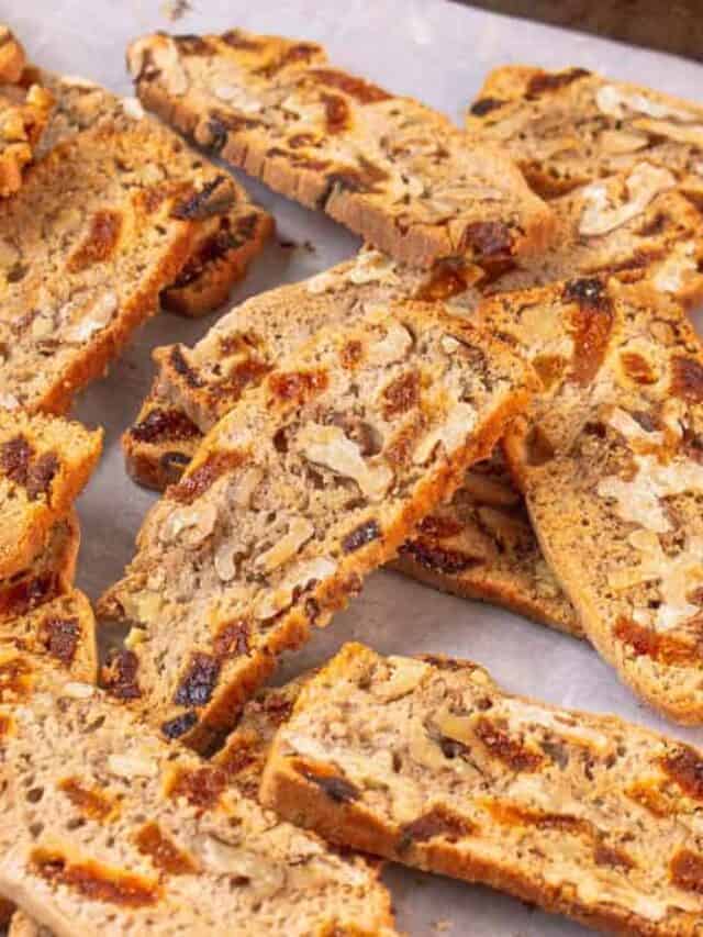 gluten free biscotti with apricots and walnuts on a baking sheet.
