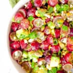 recipe for grape salad with avocado and cojita cheese in a white bowl