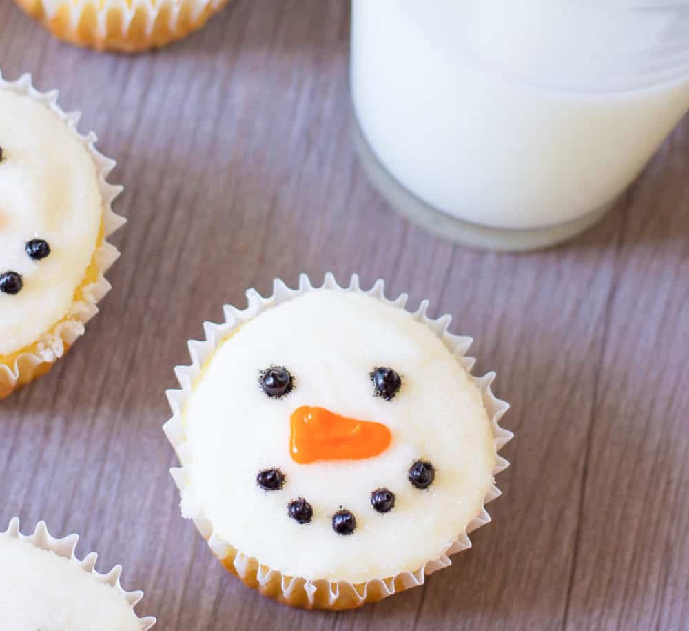 closeup of snowman cupcakes against a grey background