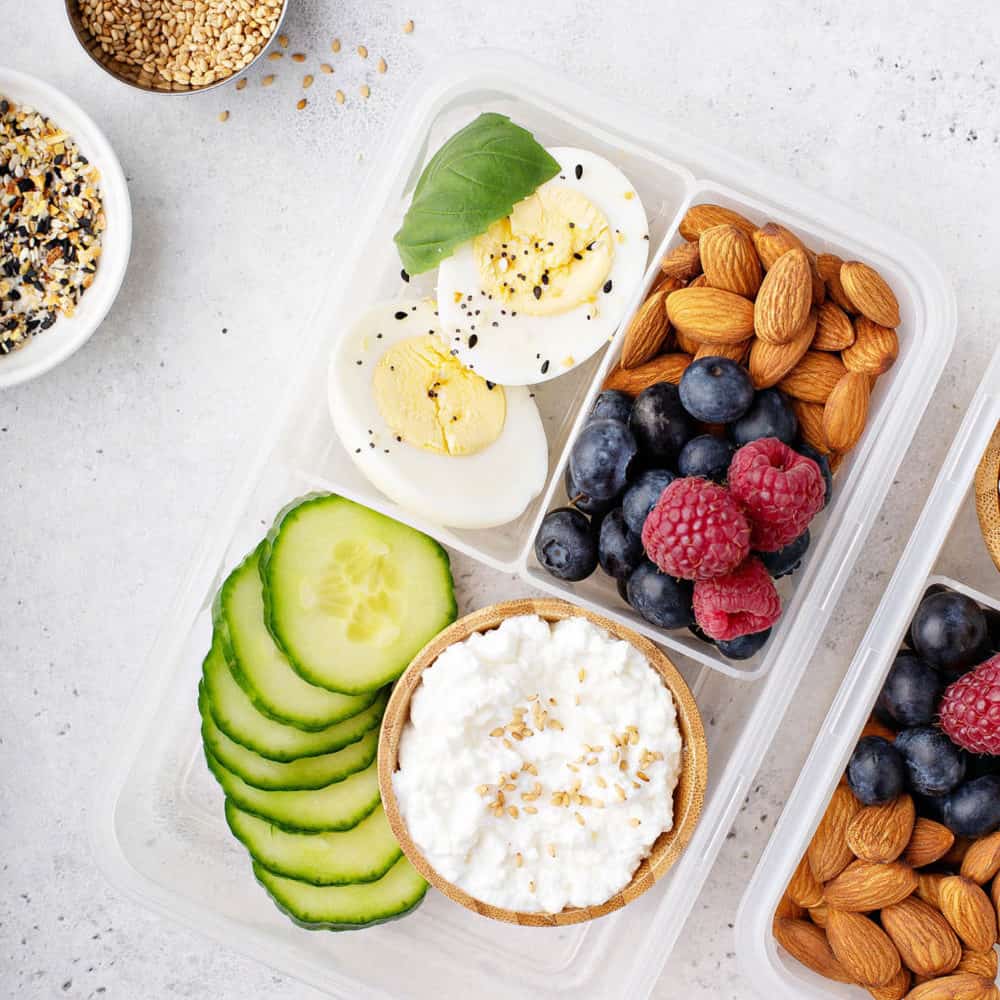 healthy snacks for toddlers - toddler snacks - bento box with hard boiled eggs, nuts, fruit, seeds, cucumbers and cottage cheese