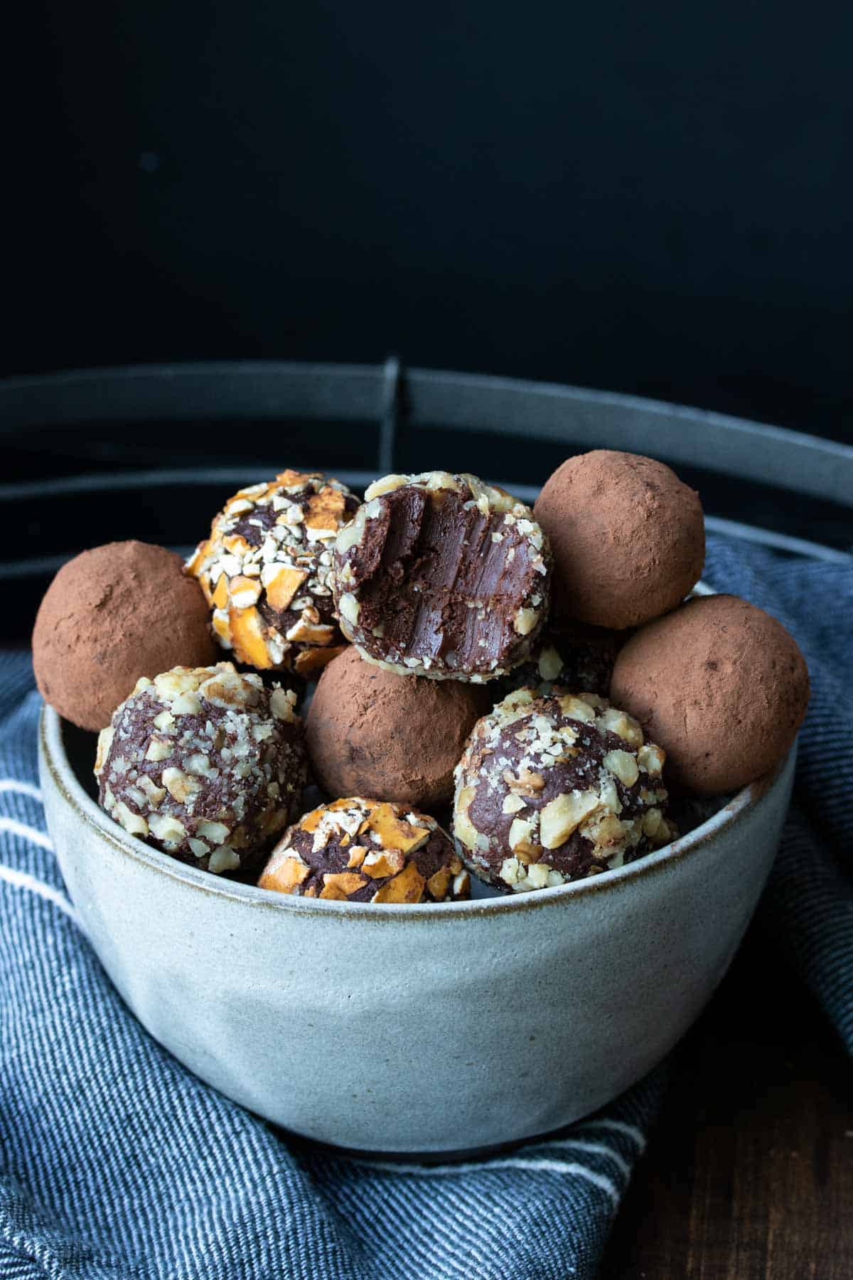 Half bitten chocolate truffle on a pile of other ones.