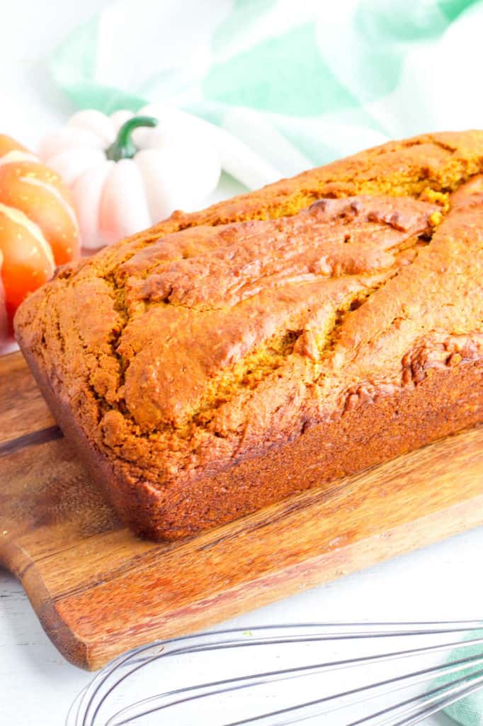vegan pumpkin bread fresh out of the oven on a wooden cutting board