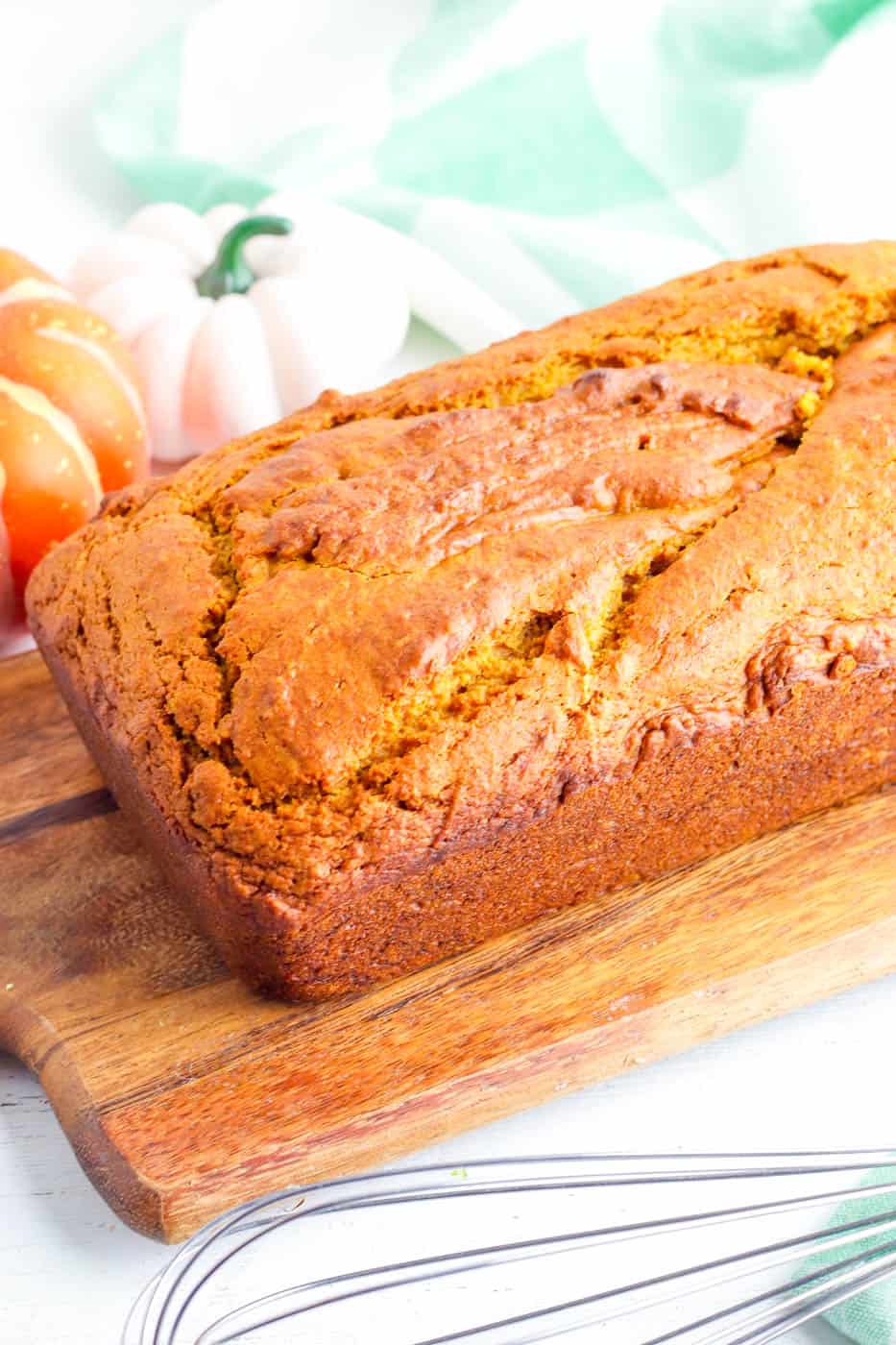 vegan pumpkin bread fresh out of the oven on a wooden cutting board