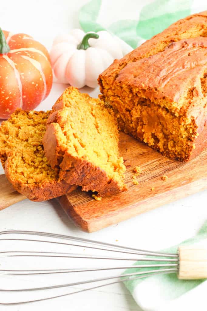 vegan pumpkin bread, sliced on a wooden cutting board