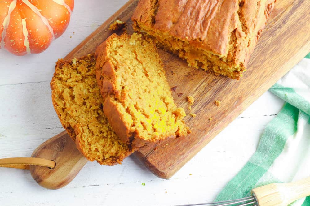 vegan pumpkin bread, sliced on a wooden cutting board