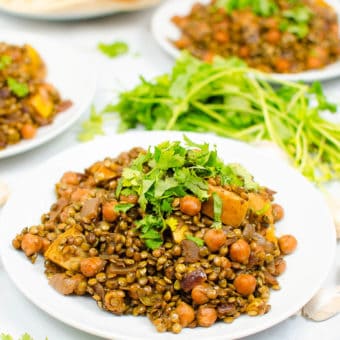 apple curry with lentils and chickpeas served on a white plate