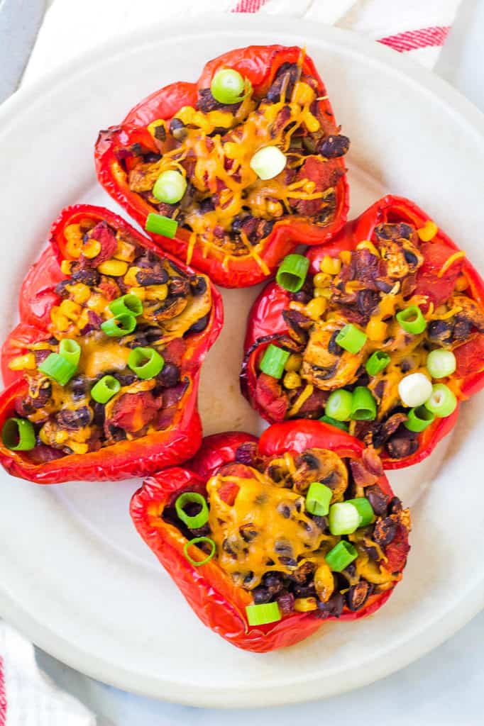 chili stuffed peppers with black beans and mushrooms, served on a white plate