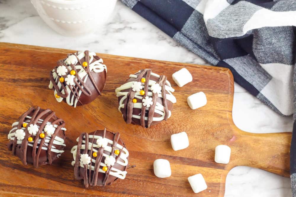 hot chocolate bombs with marshmallows on a cutting board