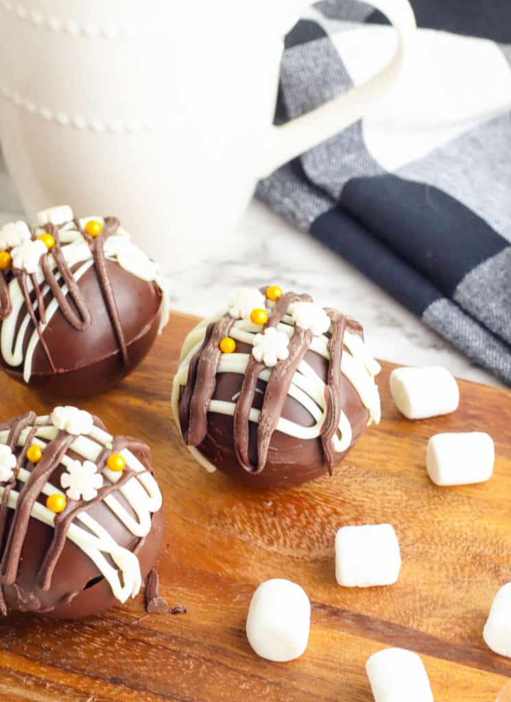 hot chocolate bombs with marshmallows on a cutting board
