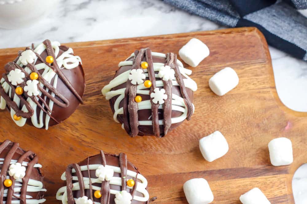 hot chocolate bombs with marshmallows on a cutting board