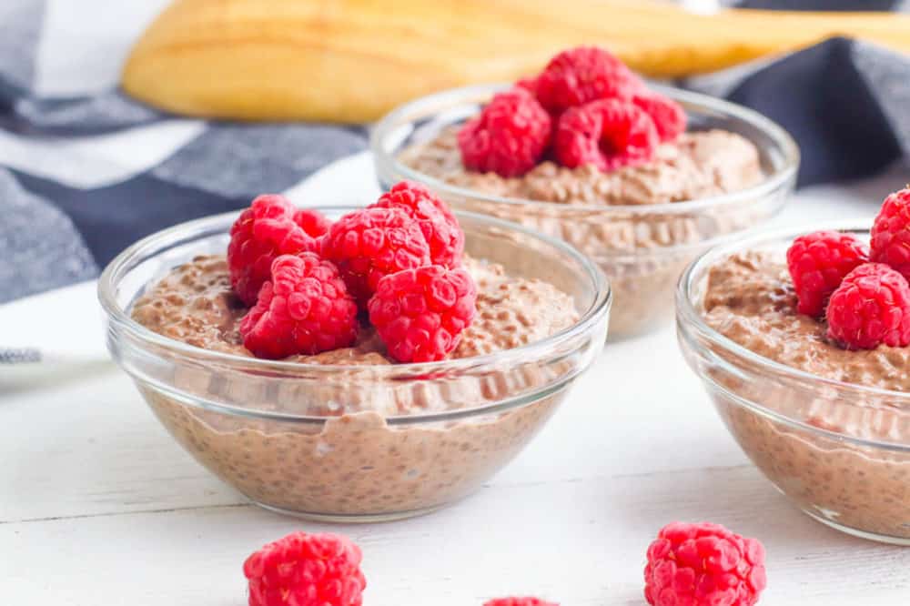 vegan chocolate mousse topped with raspberries served in a glass bowl - natural sugar vs. added sugar