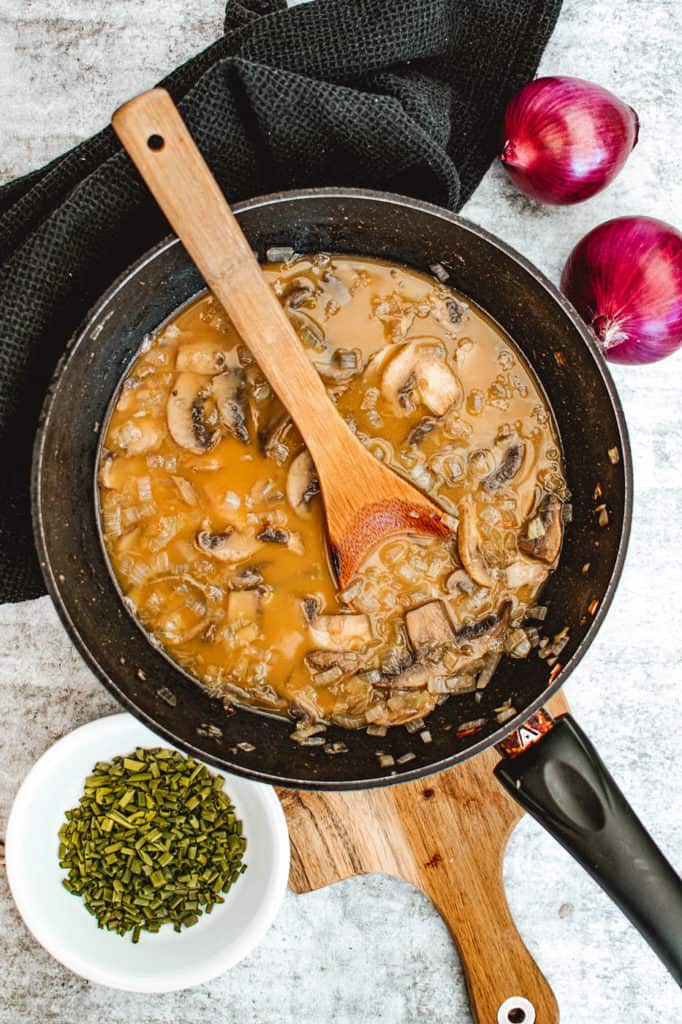 mushrooms and broth sauteeing in a pan