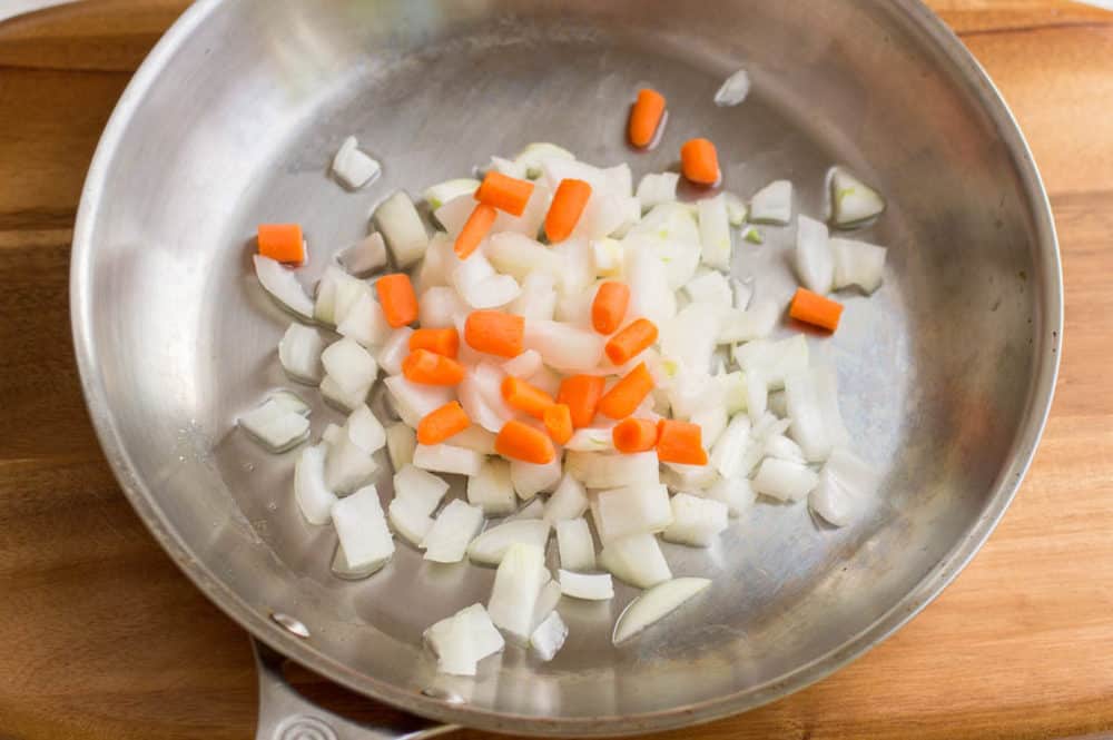 onions and carrots sauteeing in a pot