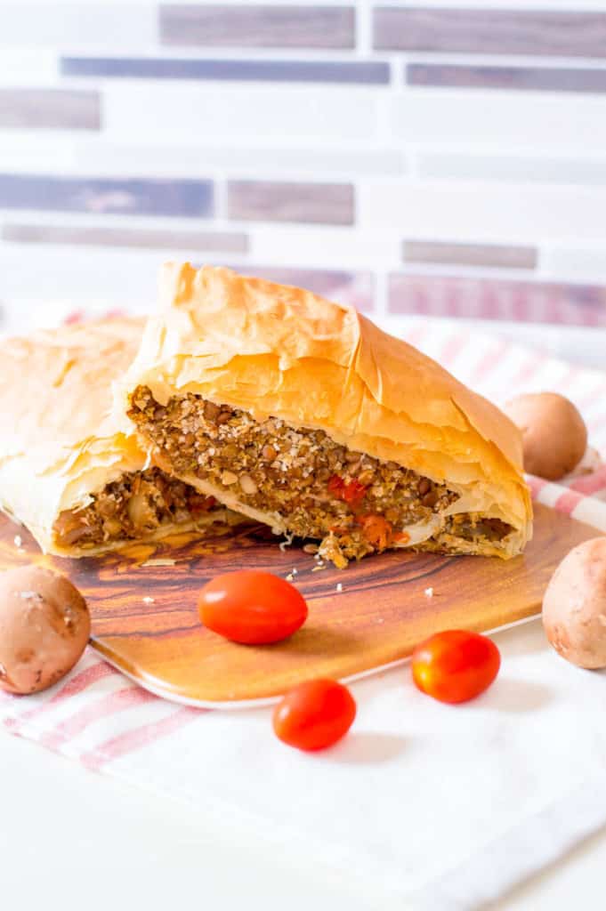 vegan wellington with lentils and mushrooms, served on a wooden cutting board