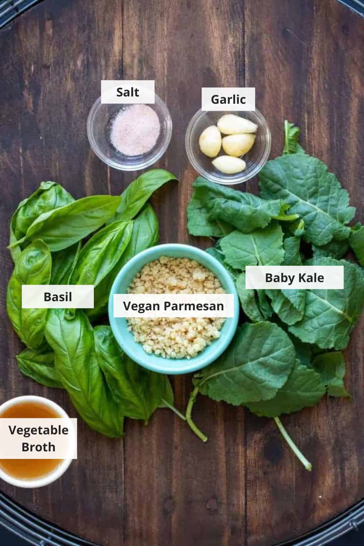 Ingredients for vegan kale pesto recipe on a wood background.