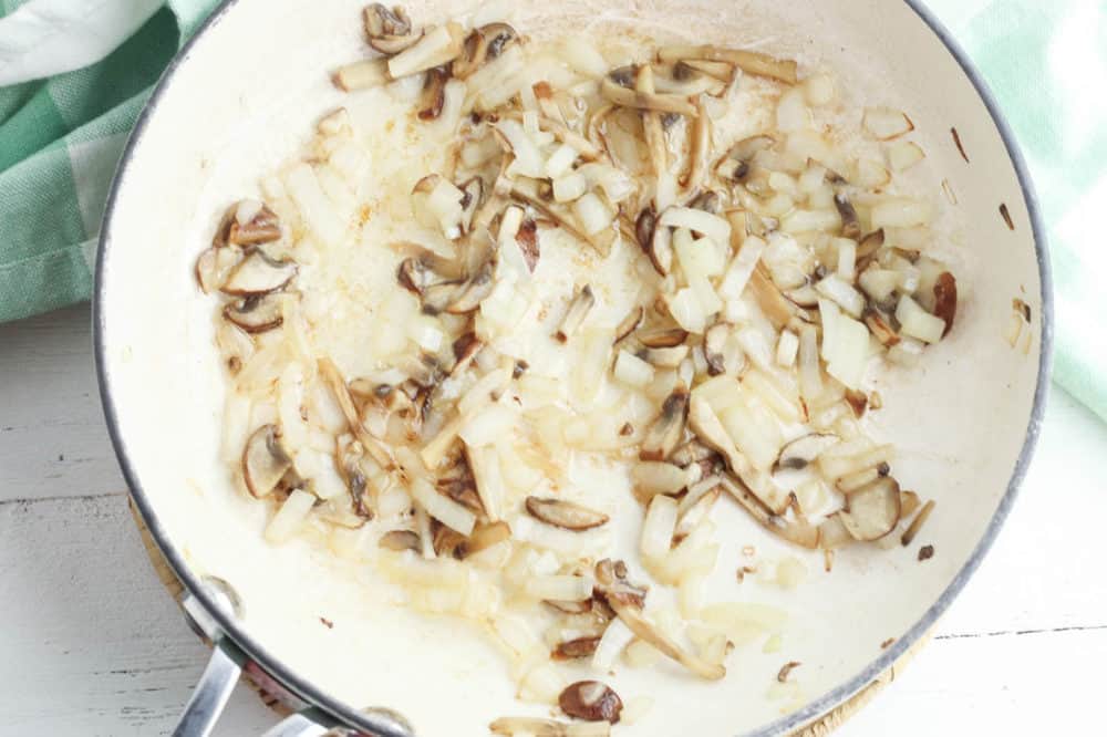 onions and mushroom sauteeing in a pan