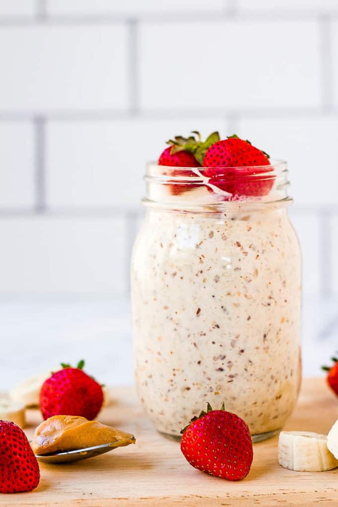 peanut butter overnight oats in a mason jar with strawberries and bananas