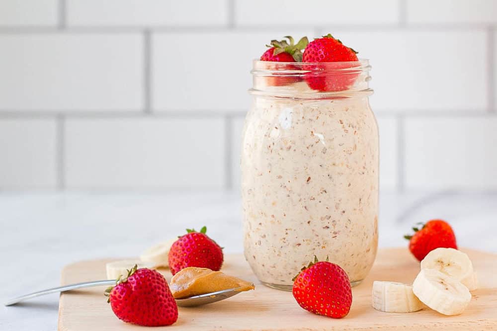 peanut butter overnight oats in a mason jar with strawberries and bananas