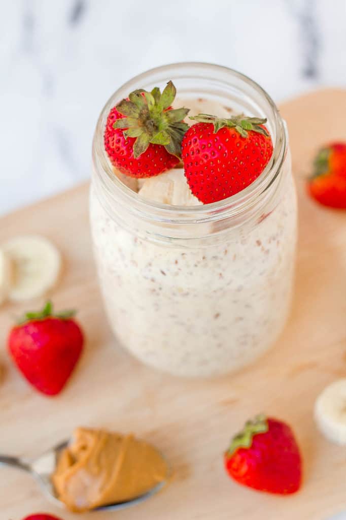 peanut butter overnight oats in a mason jar with strawberries and bananas - high protein vegan breakfast ideas