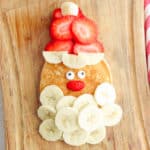 santa pancakes - christmas and holiday breakfast - made with bananas for a beard, strawberries for a hat, and candy eyes on top of a homemade pancake