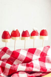 strawberry santa hats with banana "bottom" and whipped cream top on wooden skewers