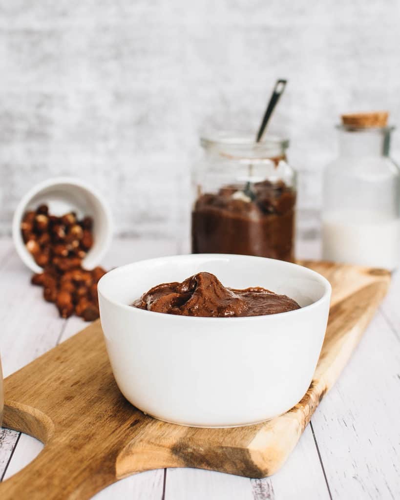 vegan nutella with hazelnuts and dark chocolate, served on a wooden cutting board