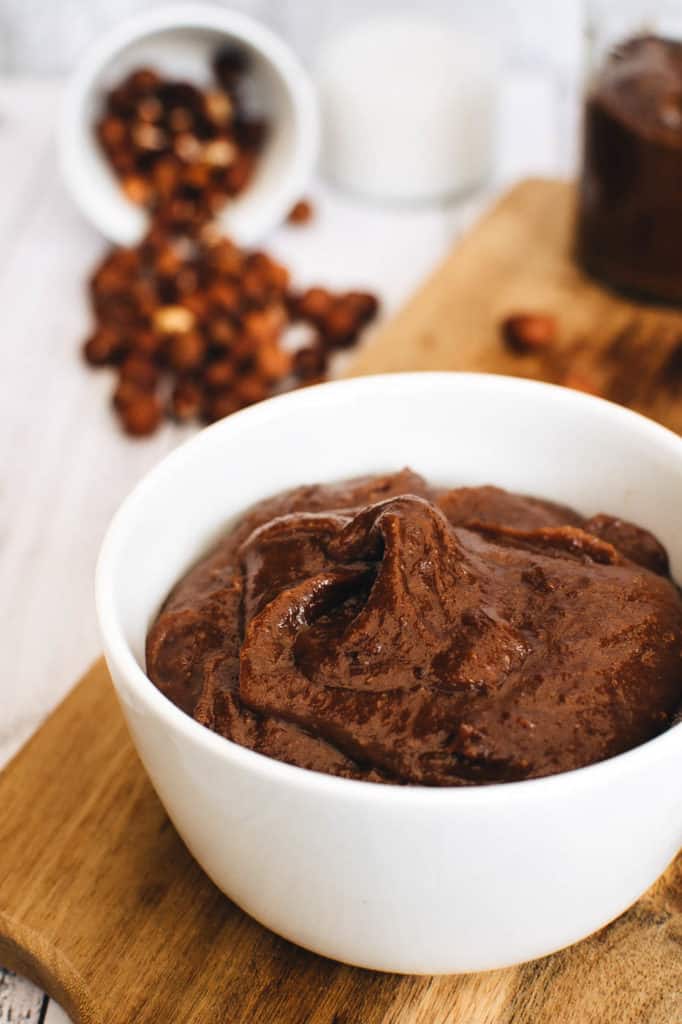 vegan nutella with hazelnuts and dark chocolate, served on a wooden cutting board - romantic desserts for two