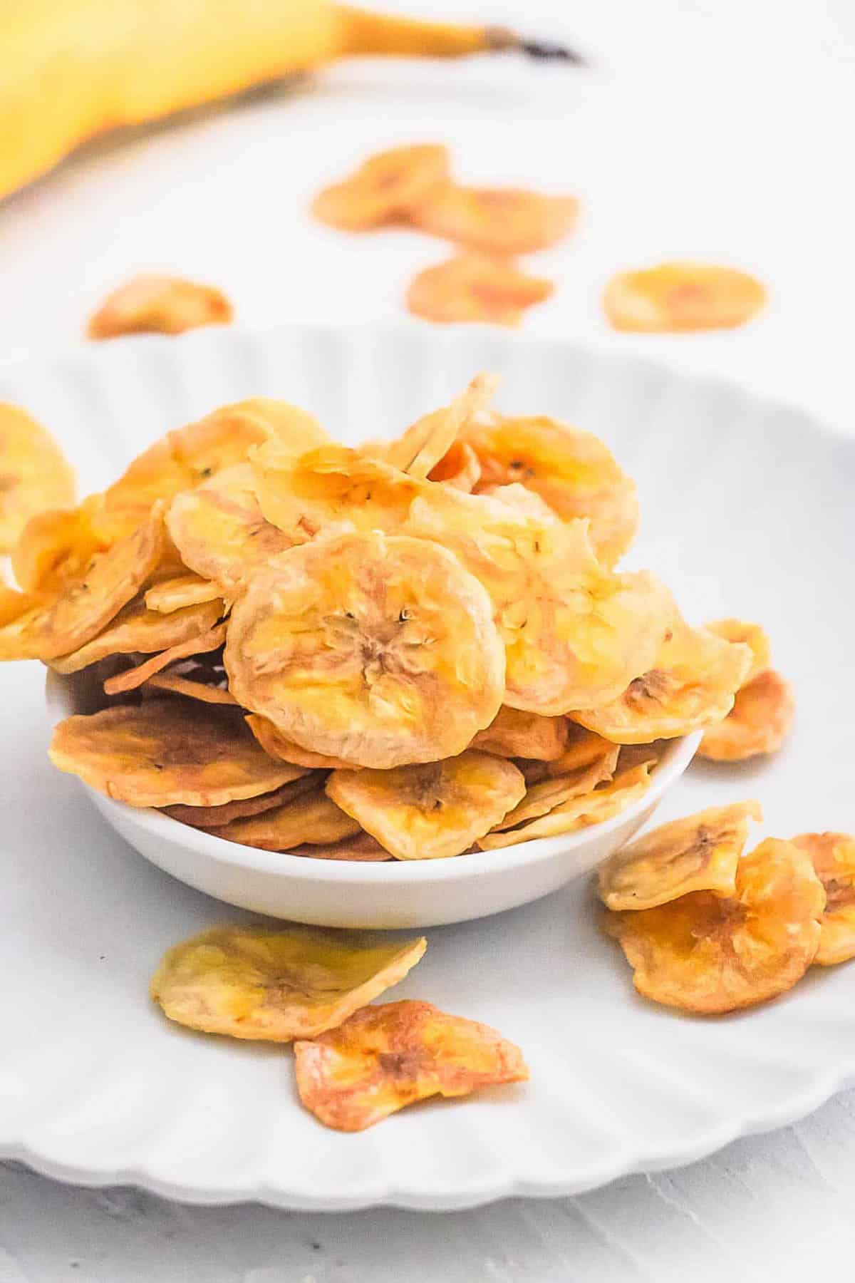 Air fryer banana chips, served in a white bowl.