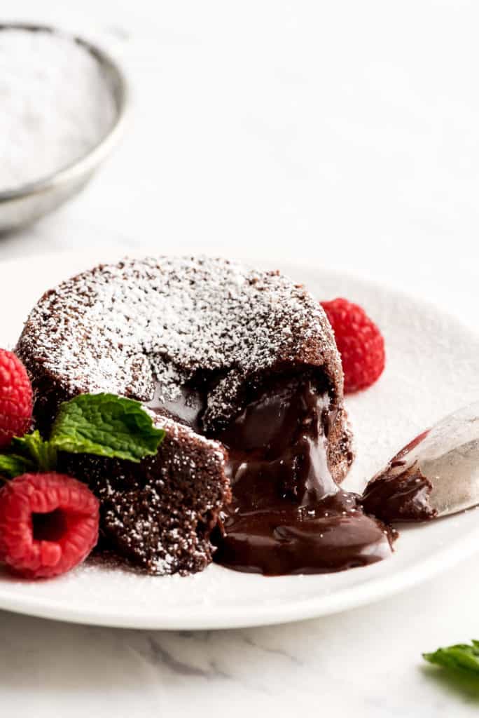molten lava cake on white plate garnished with raspeberries