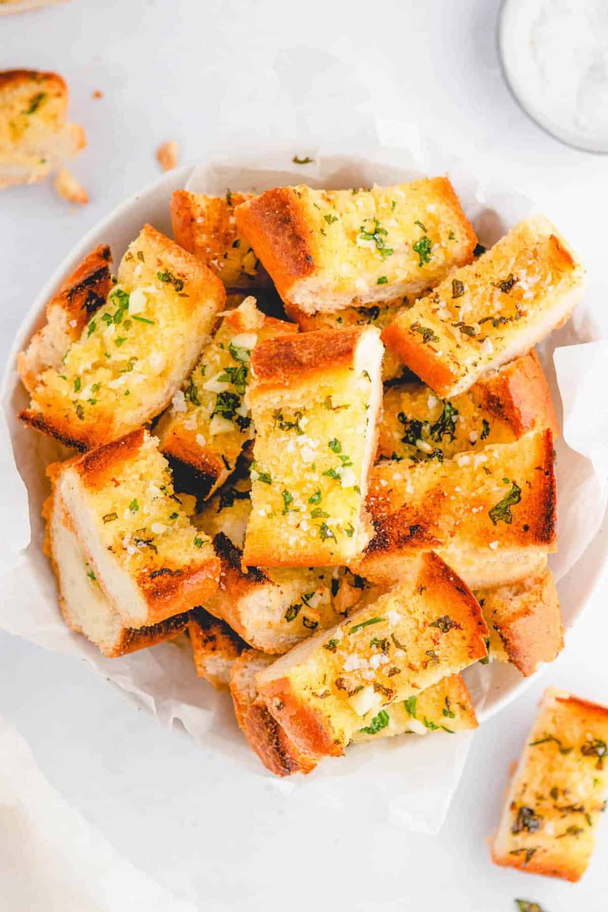 Vegan air fryer garlic bread, served in a white bowl.