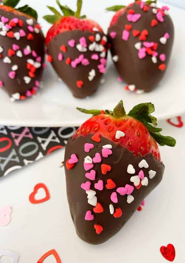 chocolate covered strawberry covered in heart sprinkles