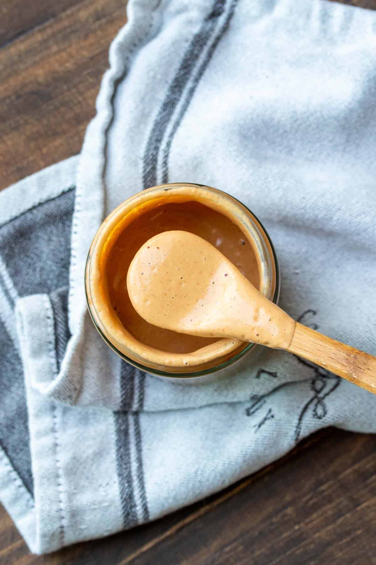 spicy paprika sauce in a jar with a wooden spoon