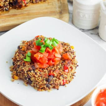 Black Bean Quinoa Cakes topped with salsa, served on a white plate