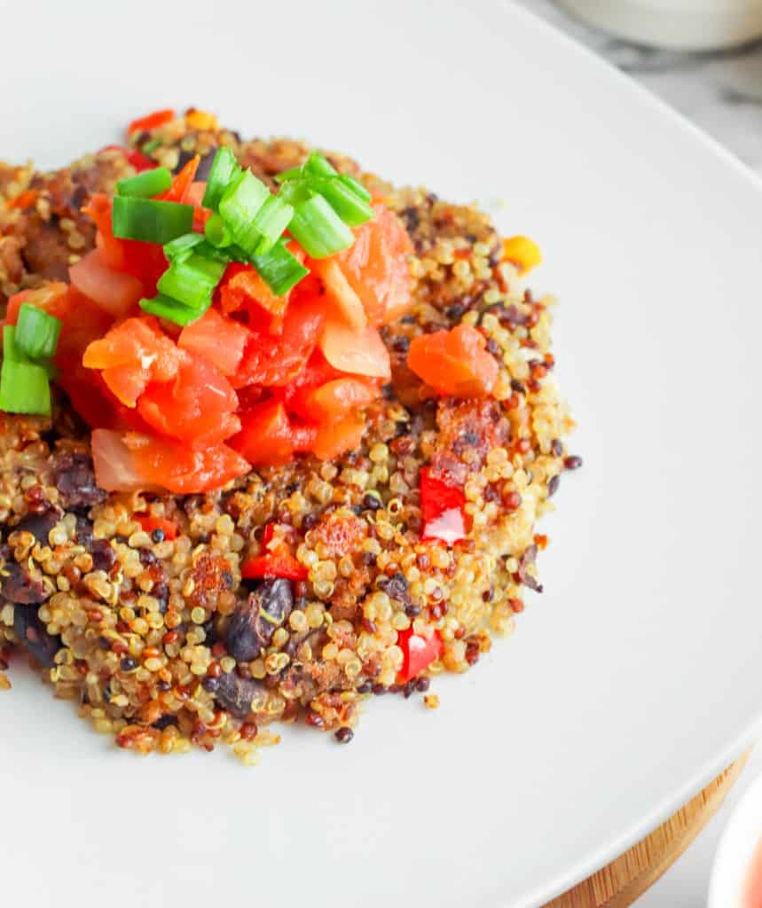 Black Bean Quinoa Cakes topped with salsa, served on a white plate