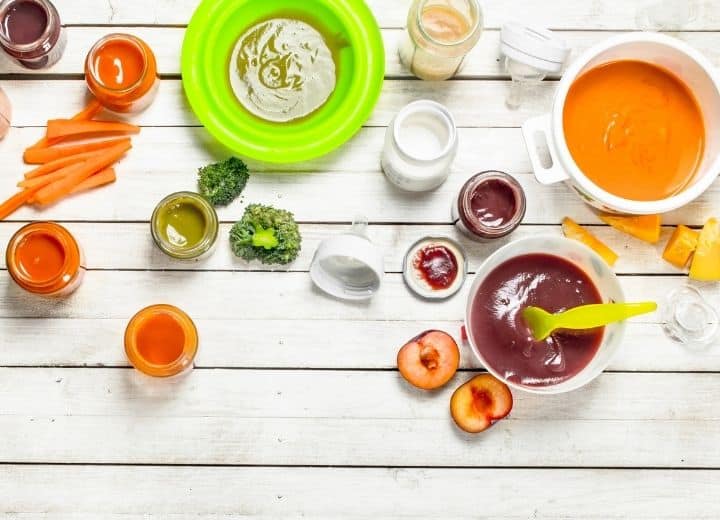 baby food in jars and bowls on white wood back drop: carrots, broccoli, squash, plums, peas - how to store homemade baby food