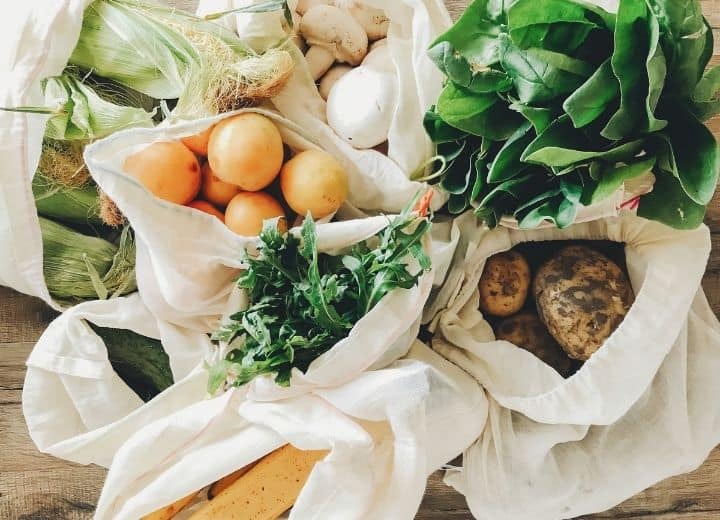 fresh produce in white grocery bags