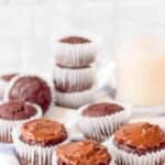 Healthy chocolate cupcakes for kids on a blue and white cloth with milk in the background.