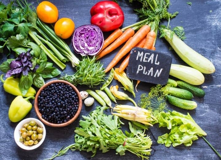 fresh produce on black backdrop with sign that reads "meal plan"